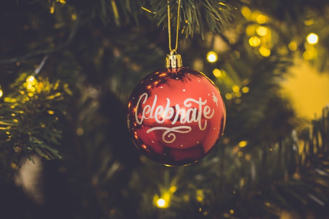 ornament on christmas tree with the word Celebrate written on it