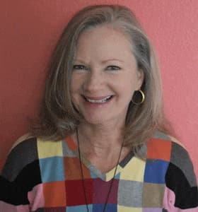Vicki Quarles headshot indoors wearing a colorful shirt