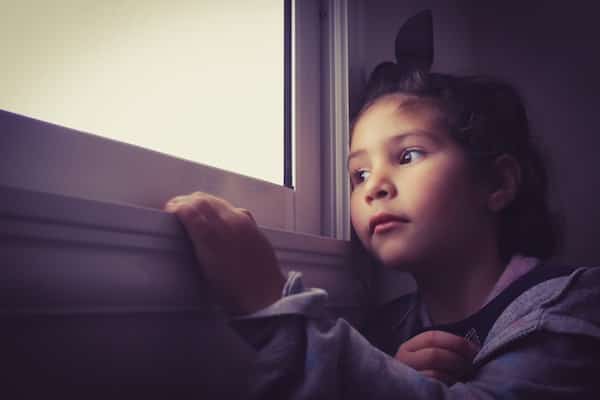 young girl looking out of window