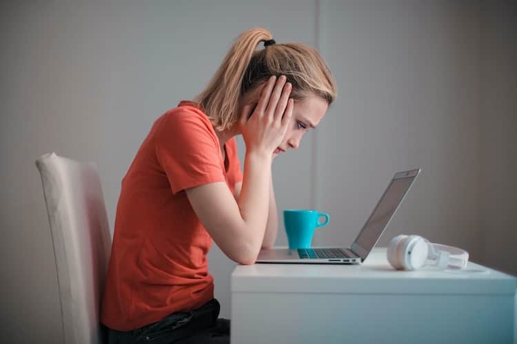 grieving woman looking at laptop