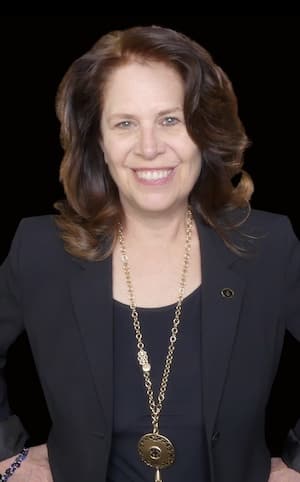 Therapist Beth Strong wearing a blazer in front of a black background