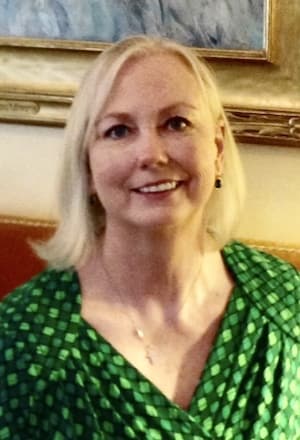 Therapist Patricia Ryan Johnson indoors wearing a green dress